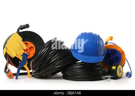 Rolled cables, hardhat, wire stripper and extension cable reels on white background Stock Photo