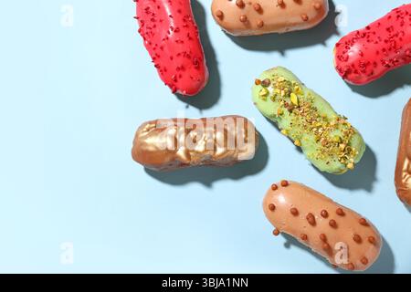 Composition with various glazed eclairs on color background Stock Photo