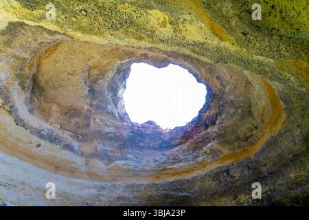 Natural opening in a Benagil Cave along the Algarve coast in Portugal. Sky seen from inside the cave on the cave tour boat. Stock Photo