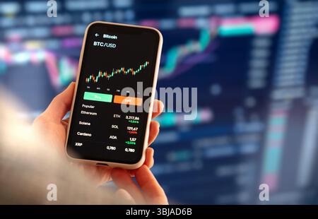 Female digital investor analyzing cryptocurrency trends on smartphone. Stock Photo