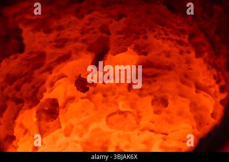 Inside of molten metal furnace. Heat texture glowing crucible in the foundry interior. Stock Photo