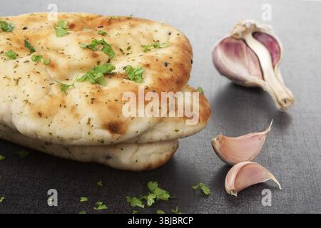 Delicious naan stack with fresh parsley and garlic on dark black and grey background. Culinary easter cuisine Stock Photo