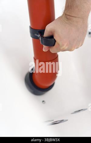 Plumber unclogging bathtub with professional force pump cleaner Stock Photo