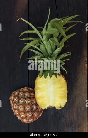 Fresh pineapple cut in half from above on wooden table Stock Photo