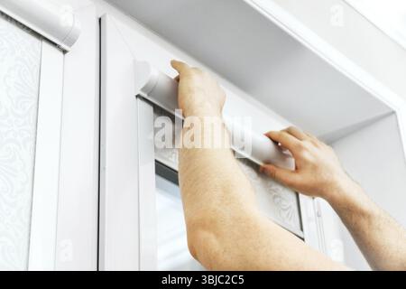 Man installing cassette roller blinds on windows Stock Photo