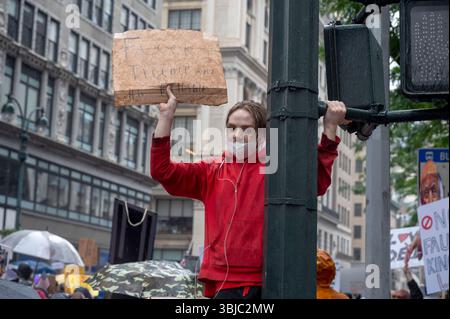 NEW YORK, NEW YORK - JUNE 14: A protester holds anti-trump sign as thousands of people march in the "No Kings" protest along Fifth Avenue on June 14, 2025 in New York City.  Marches and protests as part of a "national day of peaceful protest" against the Trump administration are happening across the United States today in opposition to his presidency and his policies.  The national protest comes as President Donald Trump's military parade celebrating the 250th anniversary of the U.S. Army is taking place in Washington, DC. Today's parade coincides with President Trump's birthday. Stock Photo