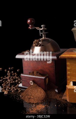 Dark elegant luxurious coffee background. Vintage coffee grinder, ground coffee and coffee beans on black background. Culinary coffee drinking Stock Photo