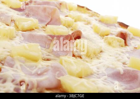 Delicious hawaii pizza with ham, pineapple and melted grated cheese detail. Traditional italian pizza eating background Stock Photo