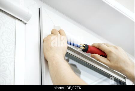 Man installing cassette roller blinds on windows Stock Photo