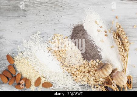 Various types of flours on wooden table from above. Rice, almonds, oat, wheat and poppy seed flour Stock Photo