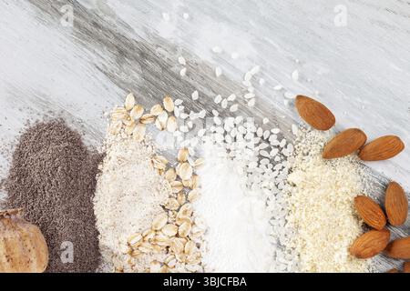 Various types of flours on wooden table from above. Rice, almond, oat and poppy seed flour Stock Photo