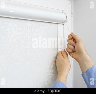 Man testing cassette roller blinds on windows Stock Photo