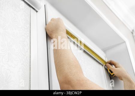 Man installing cassette roller blinds on windows Stock Photo