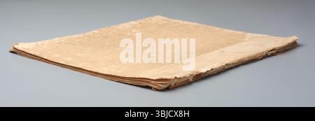 old faded or distressed beige color paperback thin book isolated gray background, wear and tear around edges, scratched and flaking off paper Stock Photo