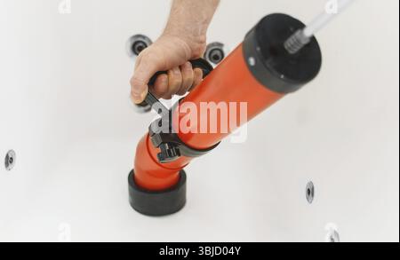 Plumber unclogging bathtub with professional force pump cleaner Stock Photo