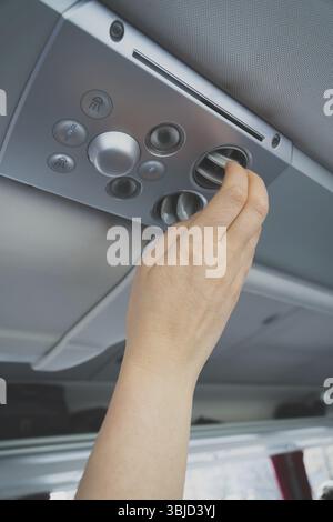 Woman checking air-conditioning system in bus Stock Photo