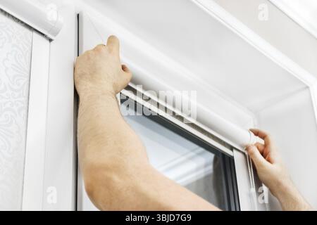 Man installing cassette roller blinds on windows Stock Photo