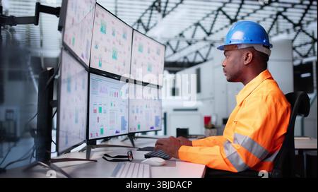 Maintenance Engineer Troubleshooting SCADA System In Modern Factory Facility. Young African-American Man Stock Photo