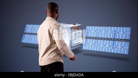 Young Engineer Using 3D CAD Software To Design Satellite Model. Stock Photo