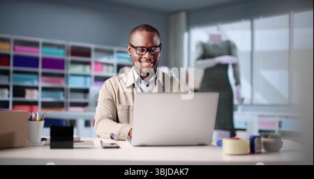 Young African-American Man Using Laptop To Design Fashion In Office. Stock Photo