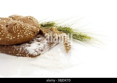 Soft & Chewy Whole Wheat breads isolated on white background with spikes of wheat Stock Photo