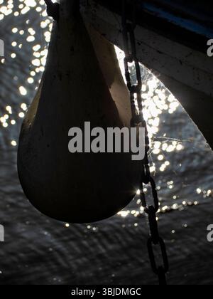 Pleasure boat bow, buoys and reeds on the Thames at Abingdon. At sunrise, the low sun creates interesting distorted reflection of boat parts, buoys an Stock Photo