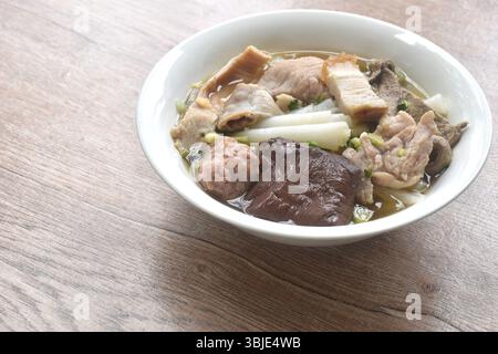large rice noodles chop and crispy pork topping blood in clear soup on bowl Stock Photo