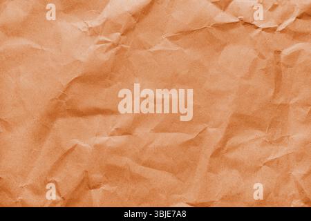 Recycled crumpled orange colored paper texture. Wrinkled craft paper background, rough cardboard surface, wallpaper, backdrop. Design element, copy sp Stock Photo