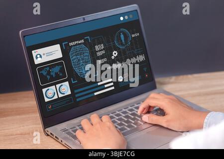 Man using a laptop to create convincing fake image, video and audio recording. Deepfake and artificial intelligence concept. Stock Photo