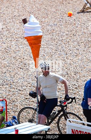 Brighton UK 15th June 2025 - Time to relax on the beach after taking part in the London to Brighton Bike ride in aid of the British Heart Foundation . The 54 mile ride begins at Clapham Common in London and finishes on Brighton seafront : Credit Simon Dack /Alamy Live News Stock Photo