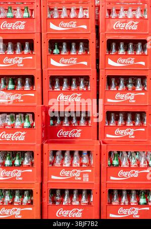 Empty soft drink glass bottles in red stacked Coca Cola boxes Stock Photo