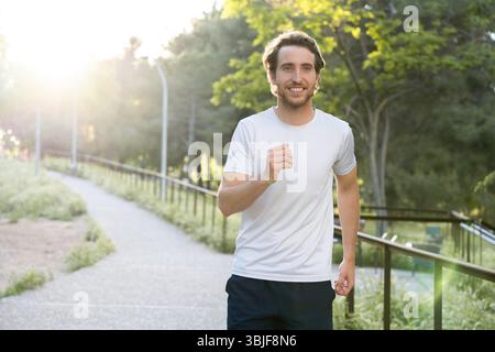 Man practicing running in the city park on a sunny afternoon Stock Photo