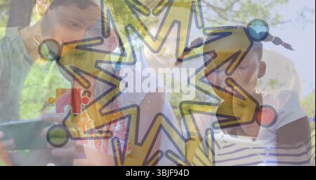 Crowding five friends gathering around tablet in park, with star overlay of interconnected icons Stock Photo