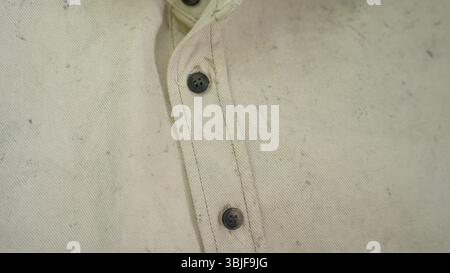 Close-Up of Beige Cotton Shirt Fabric with Black Buttons Stock Photo
