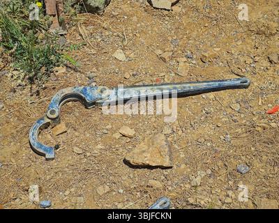 A large pipe wrench discarded on the rocky ground during a descent from Mount Kungyrbuka. May 2025 Stock Photo