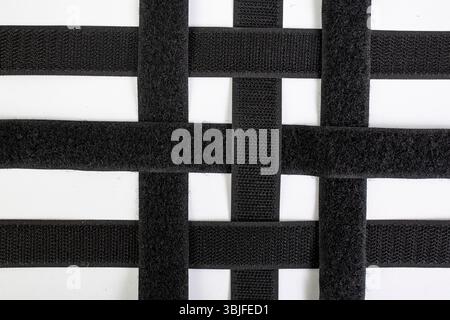 Velcro sticky tape strips pairs overlapping in a grid pattern, isolated on white background,   close up Stock Photo