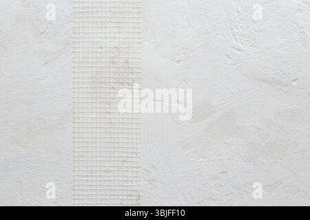 Plastic covering mesh band for even plastering on a white grungy wall, abstract textured  backdrop Stock Photo