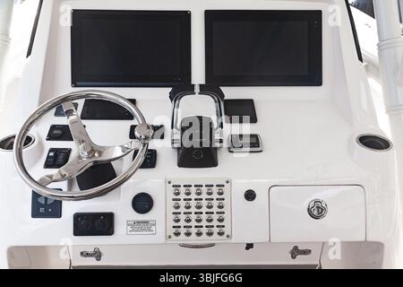 Luxury yacht control panel with steering wheel, gear levers, navigation devices, control buttons and on-board computer. Stock Photo