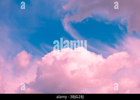 Pink and turquoise hues blend seamlessly in a sky filled with wispy cirrus clouds and fluffy cumulus formations, creating a dreamy and ethereal atmosp Stock Photo