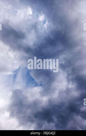 Gray cirrostratus clouds covering almost all the sky, small glimpse of blue sky behind clouds, Finland Stock Photo