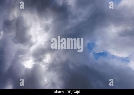 Gray cirrostratus clouds covering almost all the sky, small glimpse of blue sky behind clouds, Finland Stock Photo