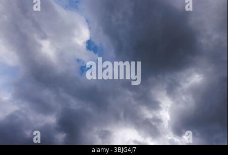 Gray cirrostratus clouds covering almost all the sky, small glimpse of blue sky behind clouds, Finland Stock Photo