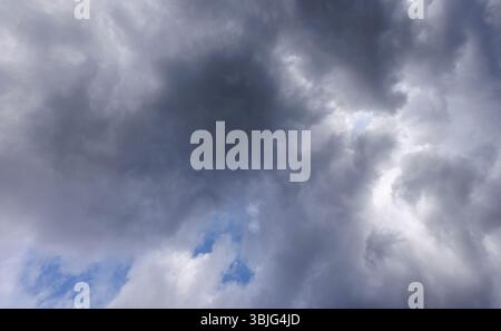 Gray cirrostratus clouds covering almost all the sky, small glimpse of blue sky behind clouds, Finland Stock Photo