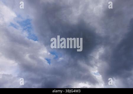 Gray cirrostratus clouds covering almost all the sky, small glimpse of blue sky behind clouds, Finland Stock Photo