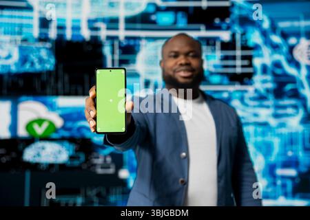 Black businessman using advanced technology and green screen on phone, exploring data science, automation and AI brain in a digital data visualization environment. Machine learning. Stock Photo
