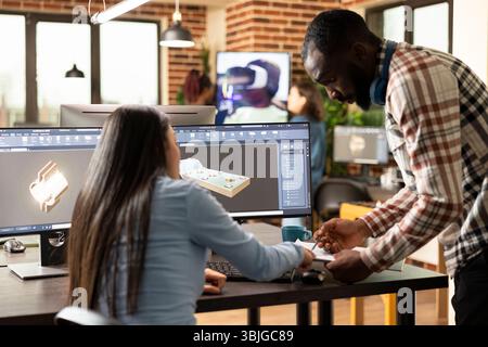 Professional male and female engineers designing an industrial engine prototype with CAD tools. Diverse creative experts exchanging ideas and sketching mechanical components on a multi monitor. Stock Photo