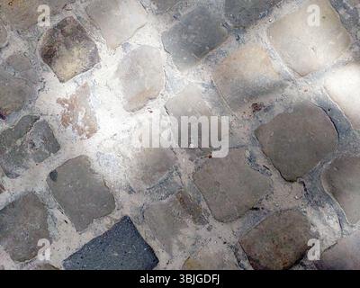 Ancient cobblestones create a unique walkway in the historic old town, illuminated by soft sunlight creating an inviting ambiance for visitors explori Stock Photo