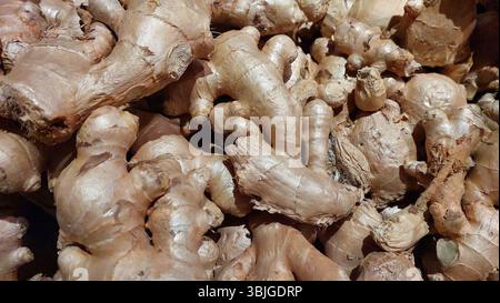 Ginger roots are displayed in a market, highlighting their earthy tones and unique shapes. The focus is on the textured surfaces and natural appearanc Stock Photo