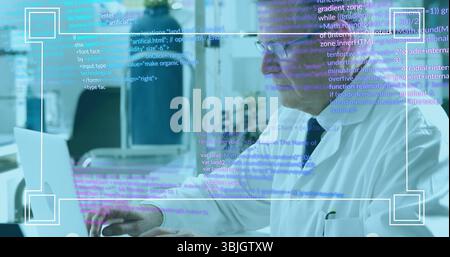 Typing senior scientist in lab coat and glasses coding on laptop in laboratory, with code overlay Stock Photo
