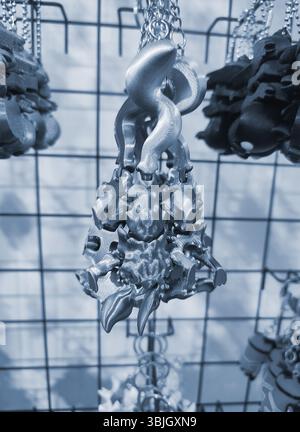 Objects keychains in form of different models of toys printed on 3D printer from molten plastic hanging on chain. Concept 3D Printing. New 3D Printing additive technology. Blue color Stock Photo